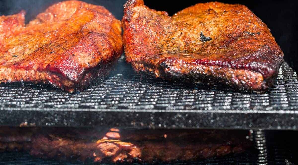 Brisket smoking on a two tier grill or BBQ.