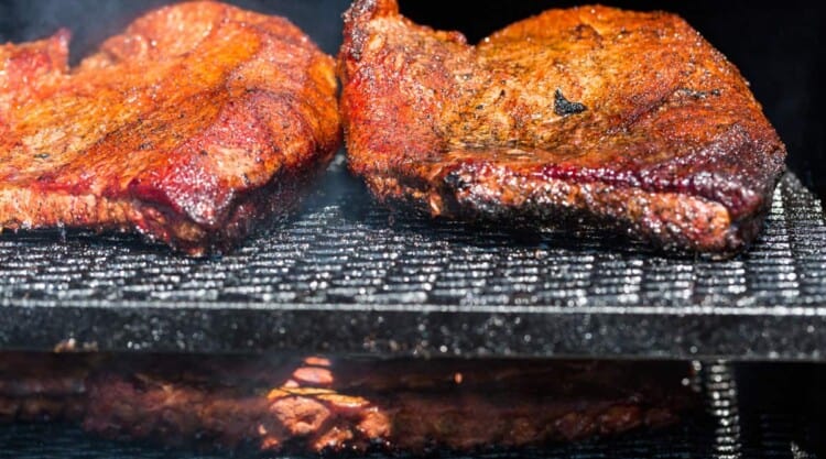 Brisket smoking on a two tier grill or BBQ.