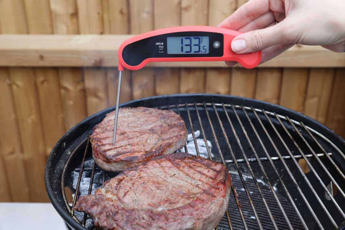 A red and black instant read thermometer reading 133.5 F in a st.