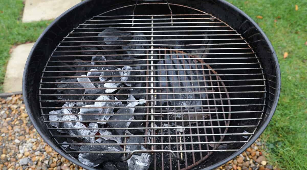 A weber kettle set up for two-zone grilling.